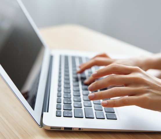 Closeup shot of woman's hands typing documents report answer using laptop keyboard staying on the table in office. Modern Online Job Work in Social Media concept